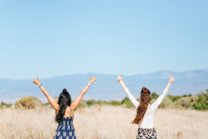 two women with arms in the air