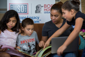 mother with children in front of USO sign